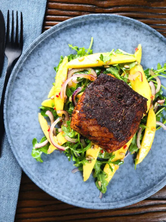 Overhead pan-fried Cajon Blackened cod fish served with mango salad.