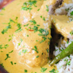 Close-up chicken drumstick rezala curry serve with jeera (cumin) rice.