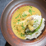 Overhead chicken drumstick rezala curry serve with jeera (cumin) rice.