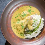 Overhead chicken drumstick rezala curry serve with jeera (cumin) rice.