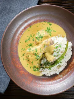 Overhead chicken drumstick rezala curry serve with jeera (cumin) rice.