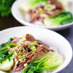 Shredded braised Chinese pork knuckle with rice and steamed pak choi.