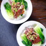 Overhead shredded braised Chinese pork knuckle with rice and steamed pak choi.