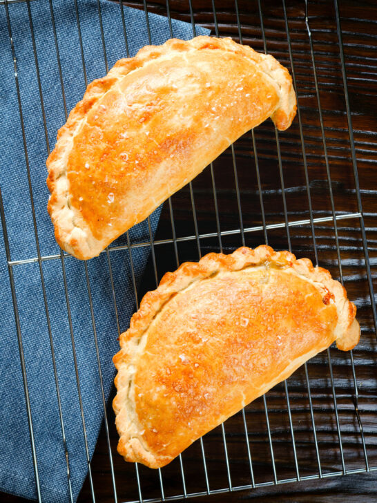 Overhead homemade corned beef, onion and potato pasties made with shortcrust pastry.