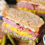 Canned corned beef sandwich with piccalilli, lettuce, cucumber and tomato on wholegrain seeded bread.
