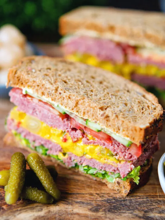 Canned corned beef sandwich with piccalilli, lettuce, cucumber and tomato on wholegrain seeded bread.