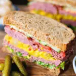 Canned corned beef sandwich with piccalilli, lettuce, cucumber and tomato on wholegrain seeded bread.