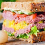 Canned corned beef sandwich with piccalilli on wholegrain seeded bread.