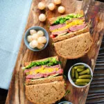 Overhead canned corned beef sandwich with piccalilli on wholegrain seeded bread.