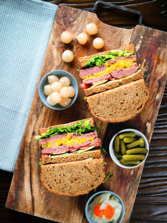 Overhead canned corned beef sandwich with piccalilli on wholegrain seeded bread.