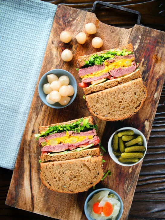 Overhead canned corned beef sandwich with piccalilli on wholegrain seeded bread.