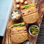 Overhead canned corned beef sandwich with piccalilli on wholegrain seeded bread.