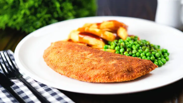 Minced beef stuffed homemade crispy pancakes with chips, peas and gravy.