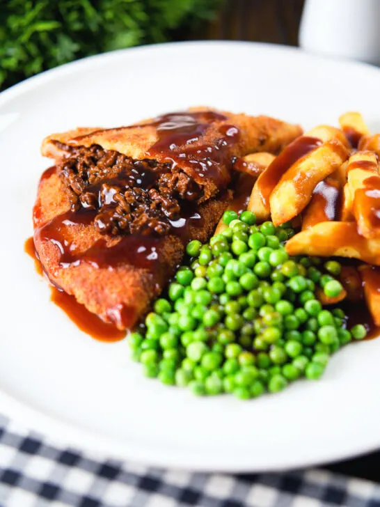 Cut-open minced beef filled crispy pancakes served with chips, peas and gravy.