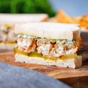 Fish finger sandwich or butty with gherkins and homemade tartar sauce on white bread.
