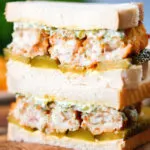 Close up fish finger sandwich with homemade tartar sauce and gherkins.