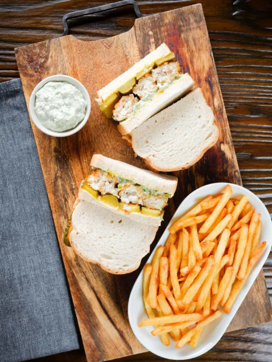 Overhead fish finger sandwich with homemade tartar sauce served with French fries.