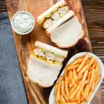 Overhead fish finger sandwich with homemade tartar sauce served with French fries.