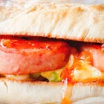 Close-up Spam, scrambled egg and spring onion sandwich with sweet chilli sauce.