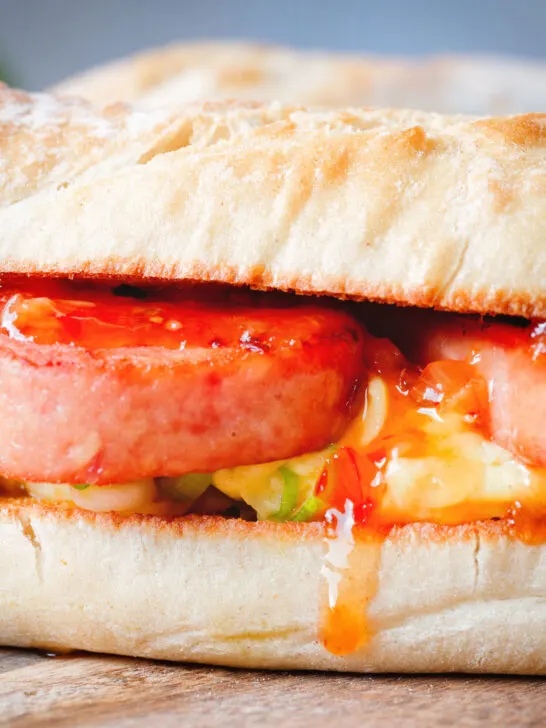 Close-up Spam, scrambled egg and spring onion sandwich with sweet chilli sauce.