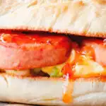 Close-up Spam, scrambled egg and spring onion sandwich with sweet chilli sauce.