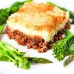 French Hachis Parmentier with a mashed potato & breadcrumb topping and green vegetables.