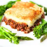 French Hachis Parmentier with a mashed potato & breadcrumb topping and green vegetables.