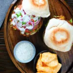 Overhead bhaji burger with tomato, cucumber, red onion, chilli and a mint raita style sauce.