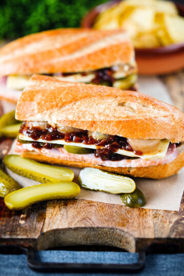 Ploughman's lunch sandwich with ham cheese and pickles on a crusty baguette.