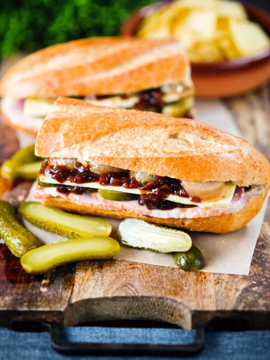 Ploughman's lunch sandwich with ham cheese and pickles on a crusty baguette.