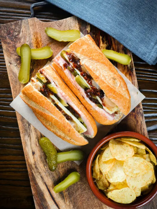 Overhead ploughman's lunch sandwich with ham cheese and pickles on a crusty baguette.