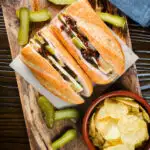 Overhead ploughman's lunch sandwich with ham cheese and pickles on a crusty baguette.