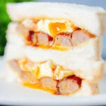 Sausage and fried egg breakfast sandwich on thick sliced white bread.