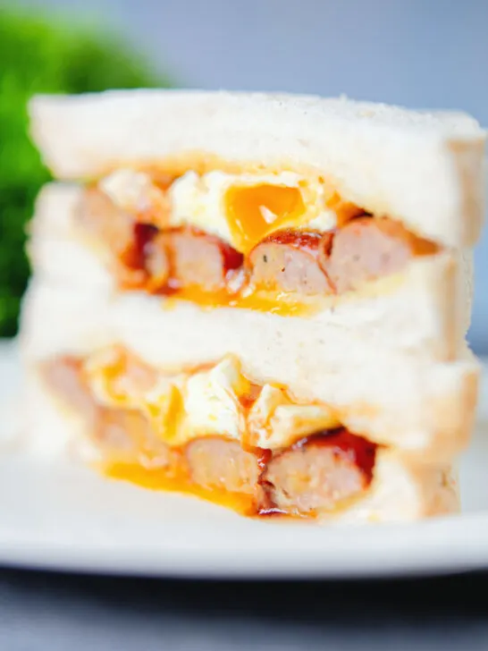 Sausage and fried egg breakfast sandwich on thick sliced white bread.