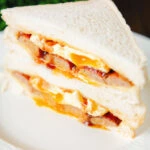 Pork sausage and fried egg sausage on sliced white bread.