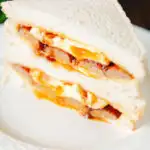 Pork sausage and fried egg sausage on sliced white bread.