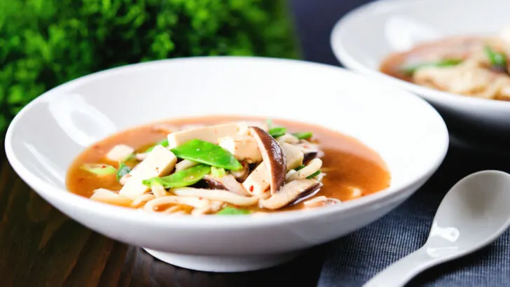 Spicy vegan miso noodle soup with silken tofu, mangetout and shiitake mushrooms.