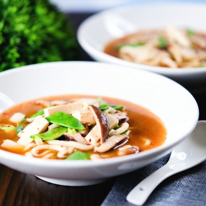 Spicy vegan miso noodle soup with silken tofu, mangetout and shiitake mushrooms.