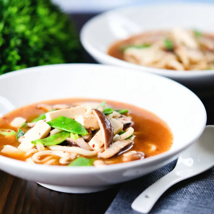Spicy vegan miso noodle soup with silken tofu, mangetout and shiitake mushrooms.