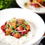 Spicy fried bang bang cauliflower garnished with ginger and coriander served with white rice.