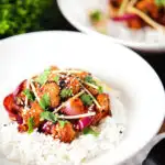 Spicy fried bang bang cauliflower garnished with ginger and coriander served with white rice.