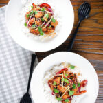 Overhead bang bang cauliflower garnished with ginger and coriander served with white rice.