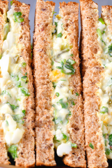 Close-up boiled egg and cress sandwiches with mayonnaise on wholemeal seeded bread.