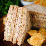 Cheese and onion sandwich with Branston pickle on malted bread served with crisps.