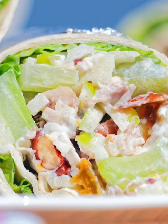 Close-up chicken Waldorf salad wraps in a flour tortilla.