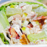 Close-up chicken Waldorf salad wraps in a flour tortilla.