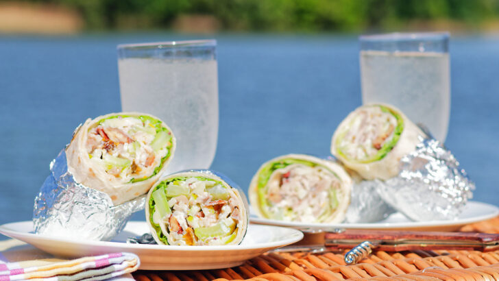 Chicken Waldorf salad wraps in a flour tortilla served on a picnic basket.