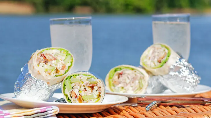 Chicken Waldorf salad wraps in a flour tortilla served on a picnic basket.