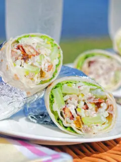 Chicken Waldorf salad wraps in flour tortillas served at a picnic.