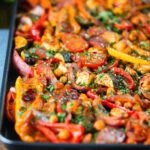 Halloumi tray bake with Mediterranean vegetables, chickpeas and spicy harissa.